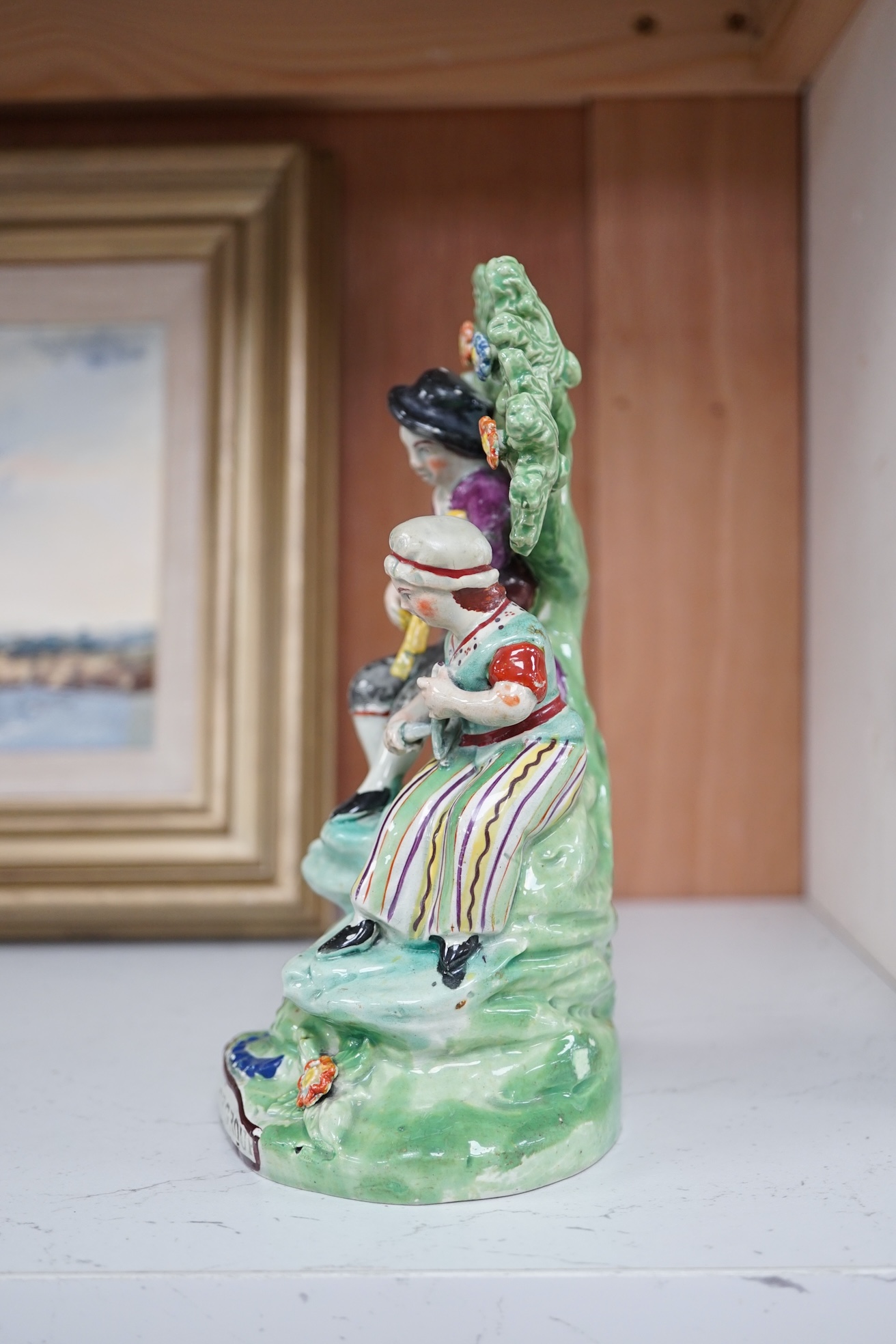 An early 19th century Staffordshire pearlware ‘village group’, 19.5cm high. Condition - fair to good